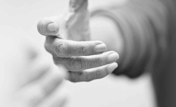 Close-up of a person's hand reaching out, symbolising legal support and assistance for clients in need of expert legal advice and representation.