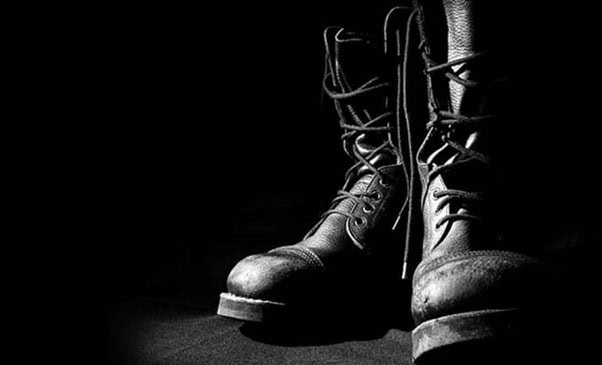 Close-up of rugged work boots in a dark setting, highlighting durability and work safety. Perfect for legal services supporting labour and employment law in Australia.