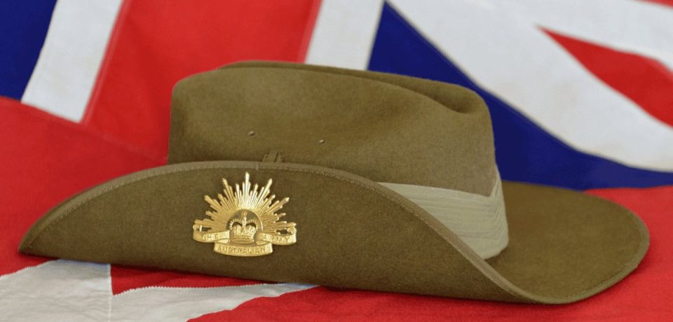 A green military-style hat featuring an Australian Defence Force badge, placed on an Australian flag symbolising military legal services and defence law expertise.