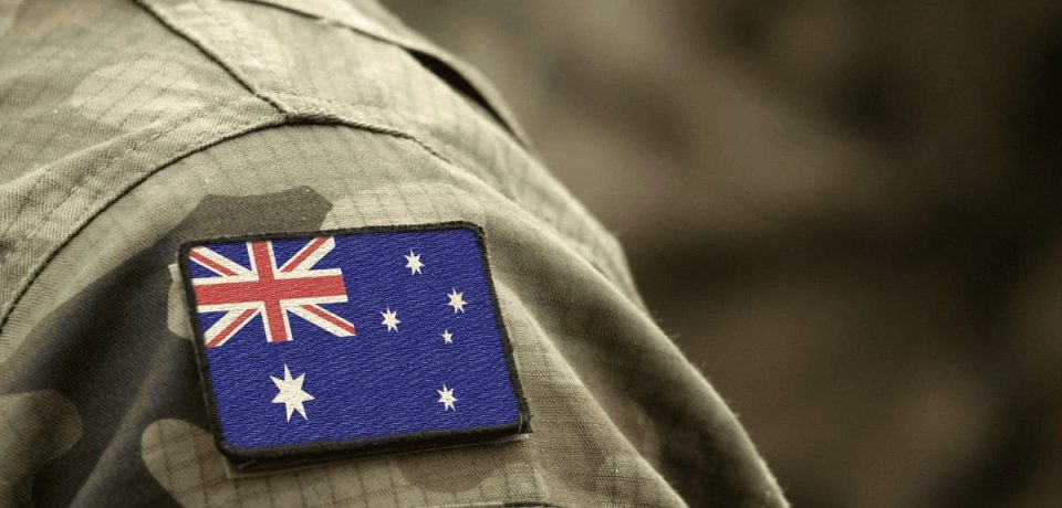 Close-up image of a camouflage military uniform with an Australian flag patch on the sleeve, highlighting national pride and military service.