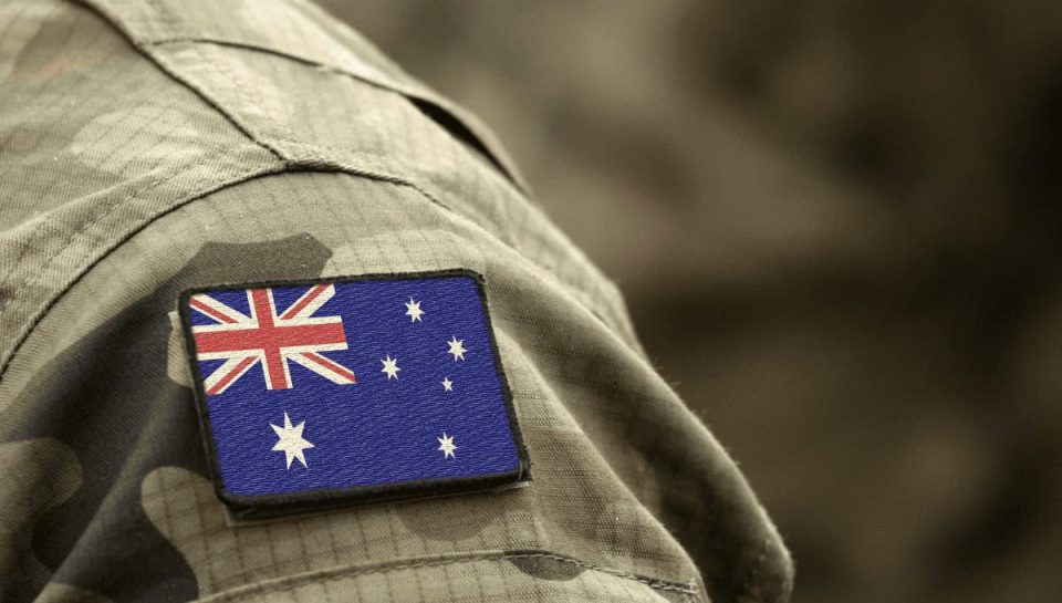Close-up image of a camouflage military uniform with an Australian flag patch on the sleeve, highlighting national pride and military service.
