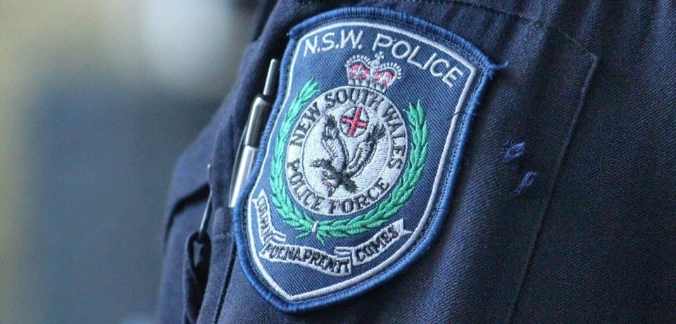 A close-up of a NSW Police officer’s uniform showing the badge with detailed insignia and embroidery, symbolizing law enforcement and community safety.